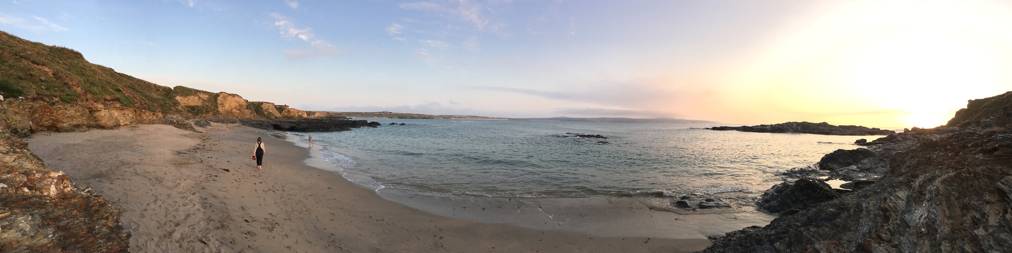 Panoramic photograph of Godrevy beach in Cornwall with the sun setting on a Spring evening.