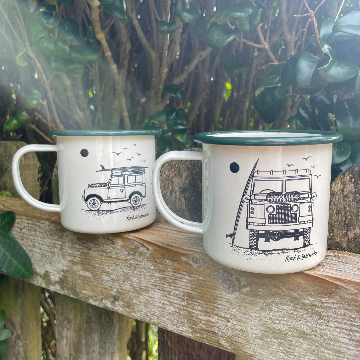 Land Rover front view with surfboard on beach enamel mug